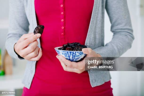 woman eating dried fruit - dried plum stock pictures, royalty-free photos & images