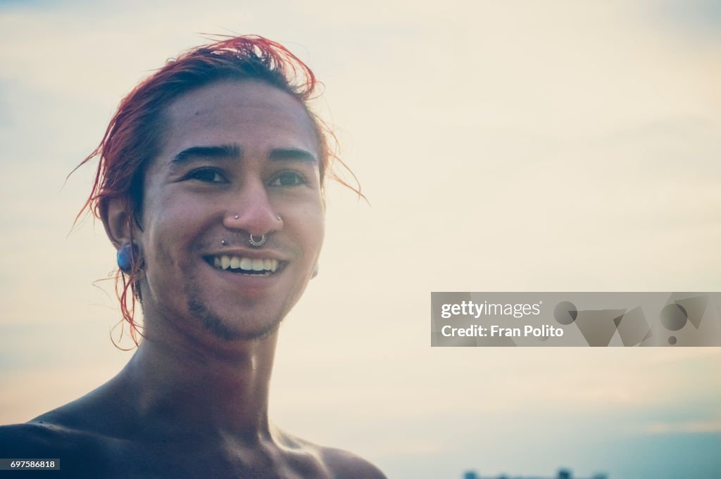 A portrait of a young man at the beach.