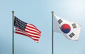 waving the American flag, the Star-Spangled Banner, the Stars and Stripes and south korean flag on blue sky, korean and us alliance, us and korean alliance