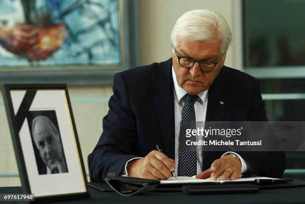 German Federal President Frank-Walter Steinmeier signs a book of condolences next to a portrait of late former German Chancellor Helmut Kohl at...