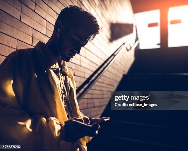 handsome fit man using his smartphone after workout - high contrast stock pictures, royalty-free photos & images