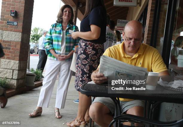 Republican candidate Karen Handel greets people as Michael Rogowski reads a paper during a campaign stop as she runs for Georgia's 6th Congressional...