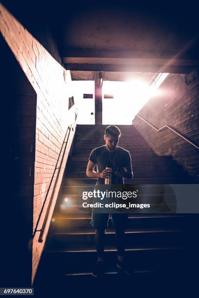 handsome fit man using his smartphone after workout - high contrast stock pictures, royalty-free photos & images