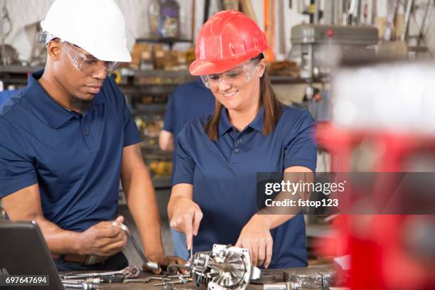 industriearbeiter, maschinisten reparaturanlagen zusammen in der fabrik. - african american mechanic stock-fotos und bilder