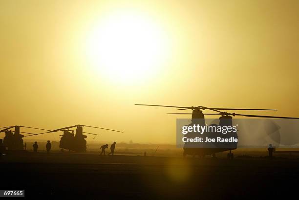 The sun sets over U.S. Air Force Alpha 7th of the 101st Airborne CH 47 D helicopters February 4, 2002 at the air base in Kandahar, Afghanistan....