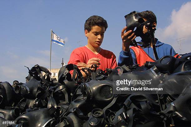 Israeli schoolboys return their gas masks after a civil defense exercise at a school February 14, 2002 in the central Israel town of Herzliya. The...