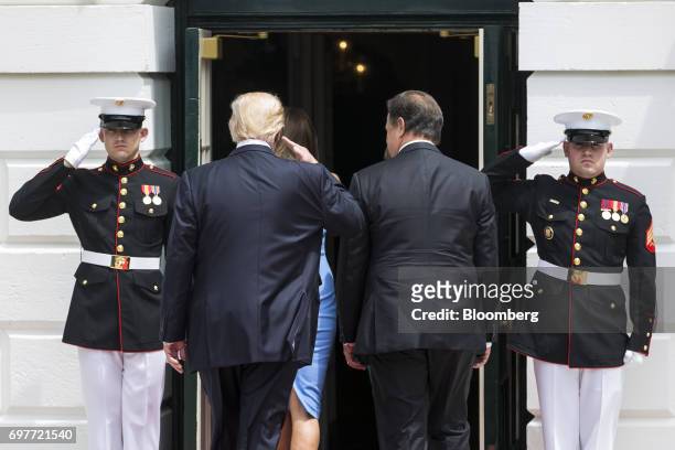 President Donald Trump, center, salutes while walking into the White House with Juan Carlos Varela, Panama's president, in Washington, D.C., U.S., on...