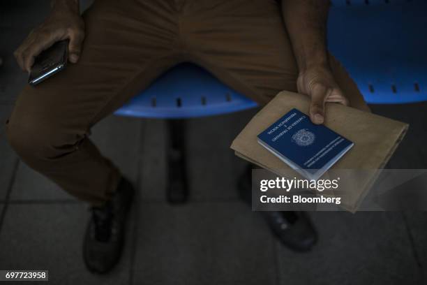 Job seeker holds work documents inside the Ministry of Labor and Employment building in Rio de Janeiro, Brazil, on Monday, June 19, 2017. The Brazil...