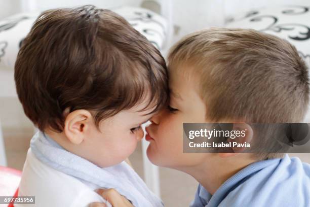 toddler (5 years) kissing his baby brother - frat boy stock-fotos und bilder