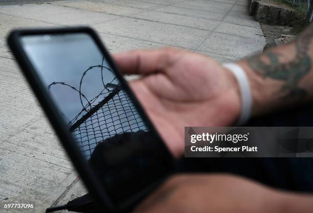 Francisco, a patient at a Brooklyn methadone clinic for those addicted to heroin, looks at the 12 steps program of Alcoholics Anonymous on his phone...