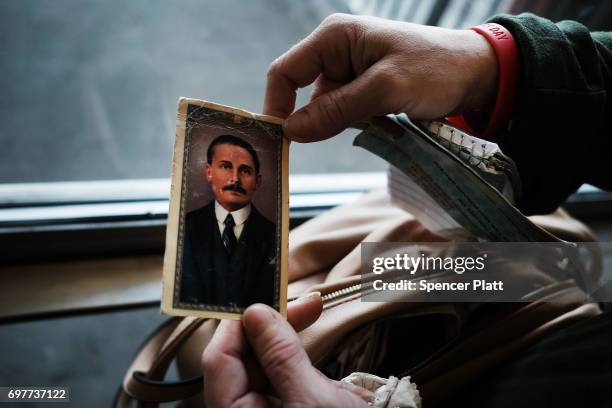 Robin, a patient at a Brooklyn methadone clinic for those addicted to heroin, displays a picture of the Venezuelan doctor and religious figure Dr....