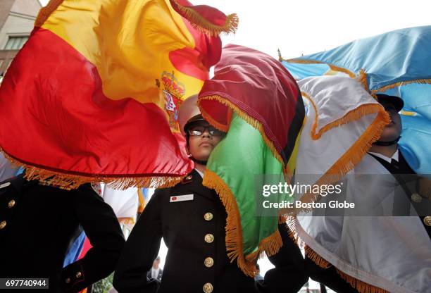 Lynn English ROTC cadet Alicia Donoso, center, stands at rest after after presenting the country flags during the Opening Ceremony of Sail Boston at...