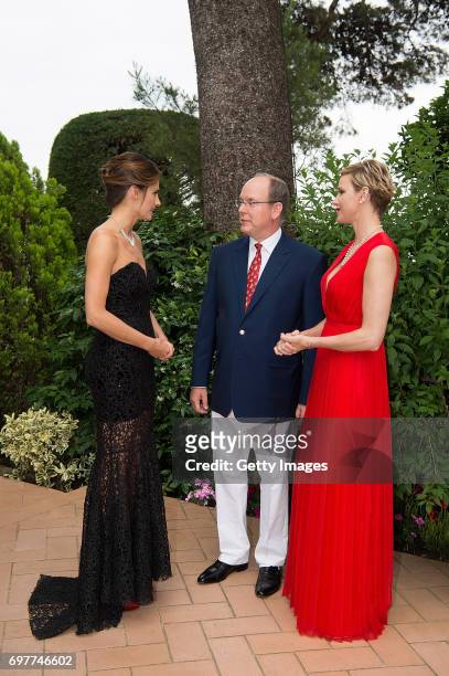 In this handout image provided by Le Palais Princier, a guest, Prince Albert II of Monaco and Princess Charlene of Monaco attend the 'The Bold and...