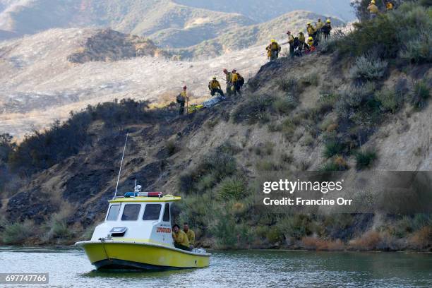 Firefighters being transported by Los Angeles County Life guards across Castaic Lake. A fast-moving brush fire yesterday near Castaic Lake has grown...