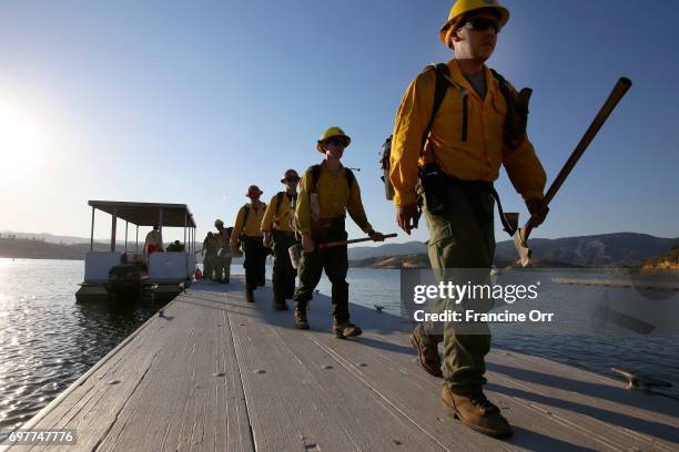 Firefighters are being transported by Los Angeles County Life guards from the fire line, across Castaic Lake. A fast-moving brush fire yesterday near...