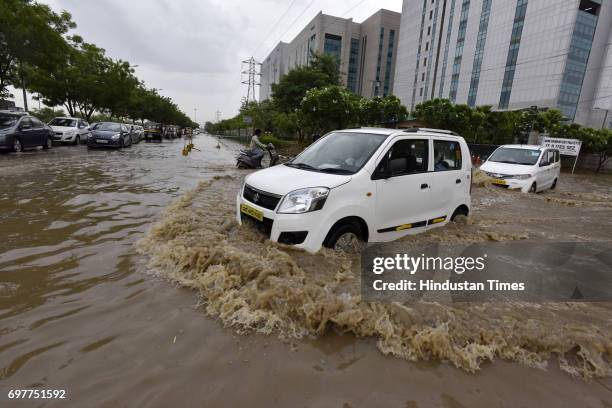 Motorists navigate a waterlogged road at Sector-48 after heavy rainfall lashed Delhi and NCR on June 19, 2017 in Gurgaon, India. With just one night...