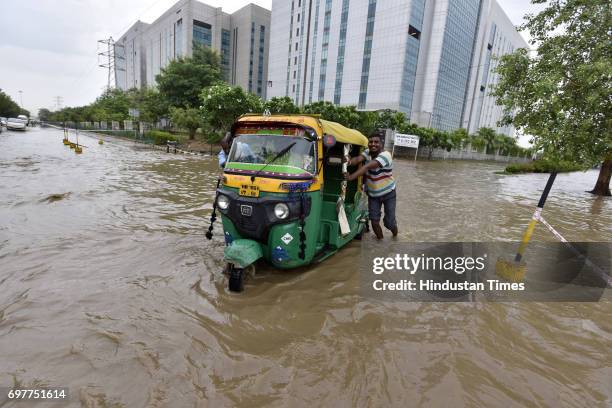 Motorists navigate a waterlogged road at Sector-48 after heavy rainfall lashed Delhi and NCR on June 19, 2017 in Gurgaon, India. With just one night...
