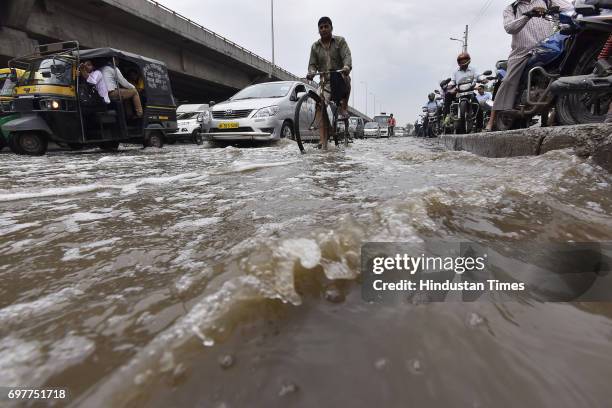 Motorists navigate a waterlogged road at Hero Honda Chowk after heavy rainfall lashed Delhi and NCR on June 19, 2017 in Gurgaon, India. With just one...