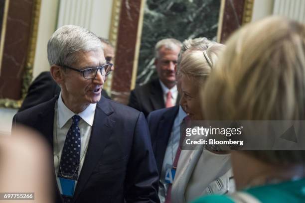 Tim Cook, chief executive officer of Apple Inc., left, speaks with Ginni Rometty, chief executive officer of International Business Machines Corp. ,...