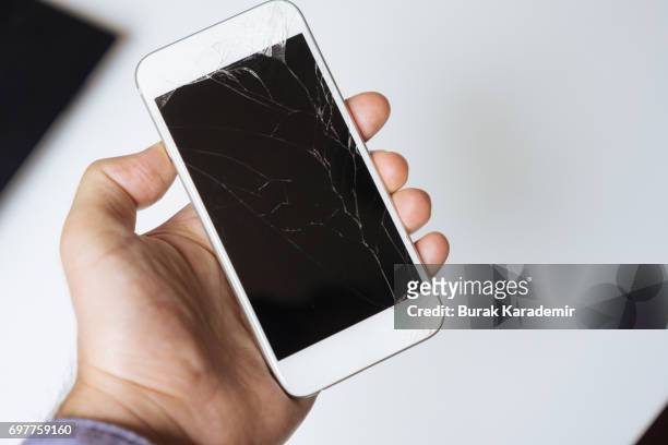 hand holding white broken phone smashed touch screen - cell destruction stock pictures, royalty-free photos & images