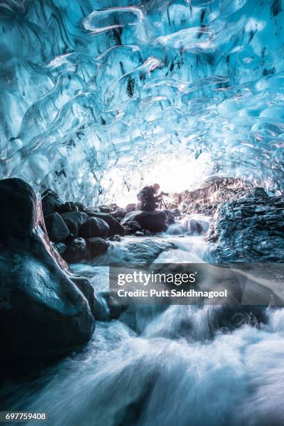 a female photographer in glacial ice cave with waterfall - jokulsarlon lagoon stock pictures, royalty-free photos & images