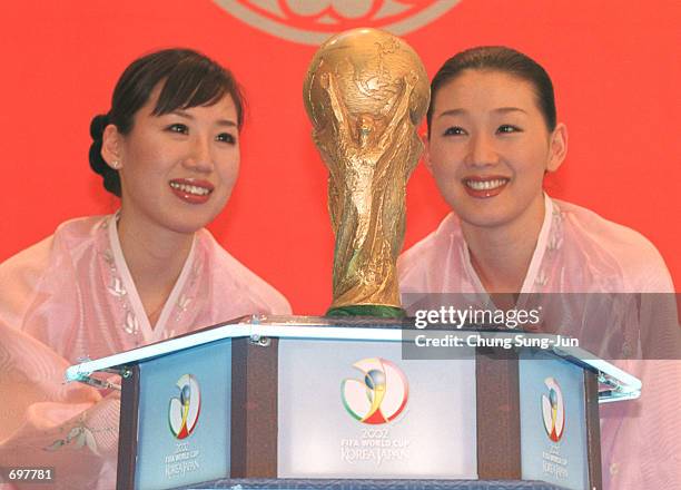 Two South Korean women pose with the 2002 Federation Internationale de Football Association World Cup trophy February 14, 2002 in Seoul, South Korea....