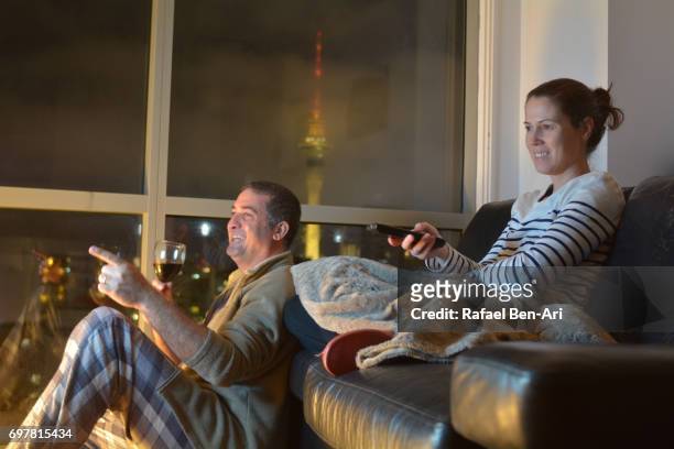 happy couple watch tv or a movie together - remote control antenna stock pictures, royalty-free photos & images