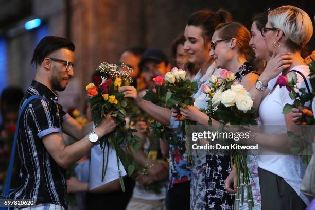 Women give flowers to a member of the muslim community as they attend a vigil outside Finsbury Park Mosque on June 19, 2017 in London, England....