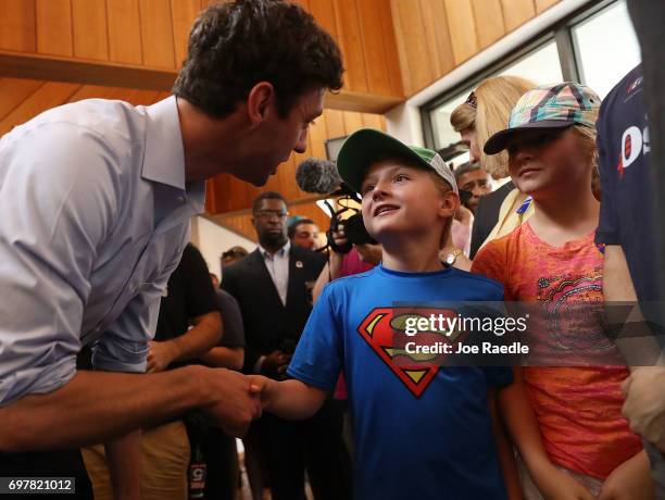 Democratic candidate Jon Ossoff shakes hands with Grayden Auchincloss during a visit to a campaign office to thank volunteers and supporters as he...