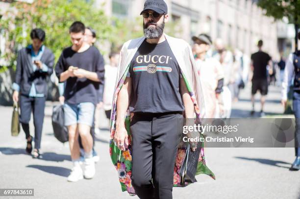 Guest wearing a black Gucci tshirt is seen outside GCDS during Milan Men's Fashion Week Spring/Summer 2018 on June 19, 2017 in Milan, Italy.