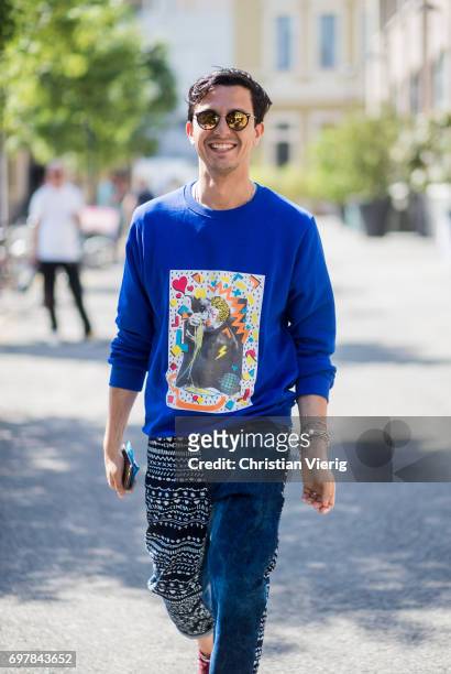 Alessandro Enriquez wearing a blue sweater with print, denim jeans is seen outside GCDS during Milan Men's Fashion Week Spring/Summer 2018 on June...