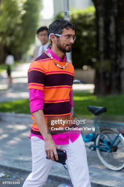 Simone Marchetti wearing a orange, striped tshirt, pink polo shirt with long sleeves, white pants is seen outside Armani during Milan Men's Fashion...