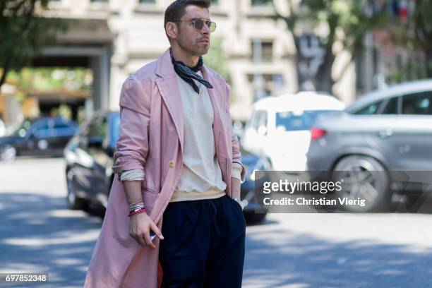 Alex Badia wearing a pink coat, scarf is seen outside Armani during Milan Men's Fashion Week Spring/Summer 2018 on June 19, 2017 in Milan, Italy.