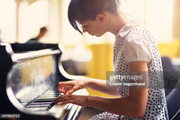 tienermeisje spelen piano concert - pianist stockfoto's en -beelden