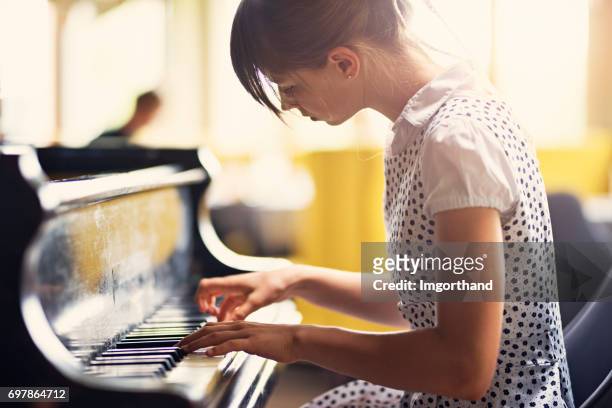 teenage girl playing piano concert - piano stock pictures, royalty-free photos & images