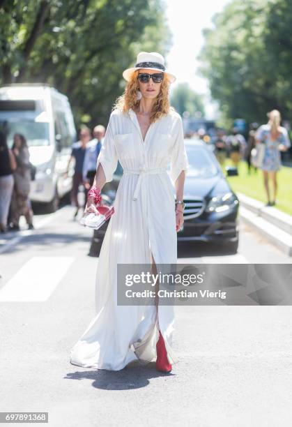 Elina Halimi wearing a white dress, straw hat, red boots is seen outside Armani during Milan Men's Fashion Week Spring/Summer 2018 on June 19, 2017...