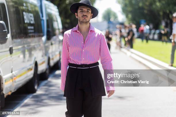 Guest wearing hat, pink white striped button shirt with long sleeves is seen outside Armani during Milan Men's Fashion Week Spring/Summer 2018 on...