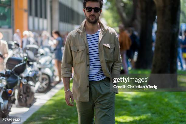 Guest wearing khaki button shirt, striped tshirt, olive pants is seen outside Armani during Milan Men's Fashion Week Spring/Summer 2018 on June 19,...