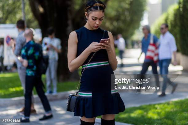 Guest wearing a navy dress, black overknees is seen outside Armani during Milan Men's Fashion Week Spring/Summer 2018 on June 19, 2017 in Milan,...