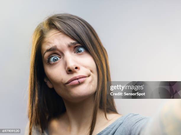 funny woman posing for a selfie against gray background. - cross eyed stock pictures, royalty-free photos & images