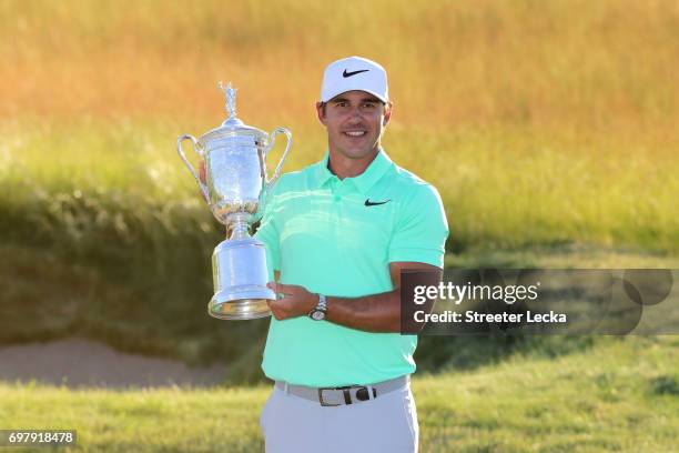 Brooks Koepka of the United States poses with the winner's trophy after his victory at the 2017 U.S. Open at Erin Hills on June 18, 2017 in Hartford,...