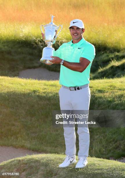 Brooks Koepka of the United States poses with the winner's trophy after his victory at the 2017 U.S. Open at Erin Hills on June 18, 2017 in Hartford,...