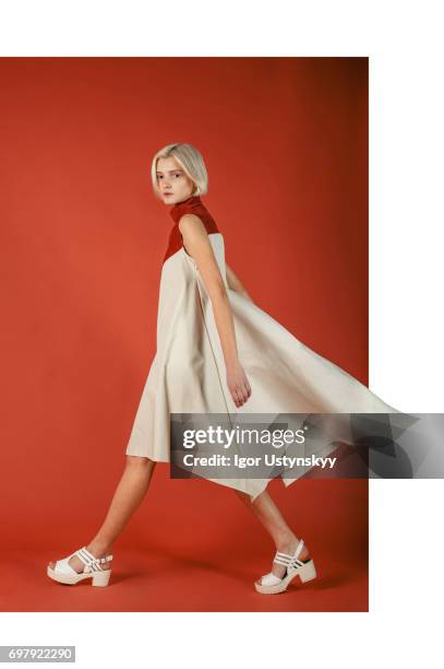 portrait of woman in studio on the red background - multi colored dress stock pictures, royalty-free photos & images