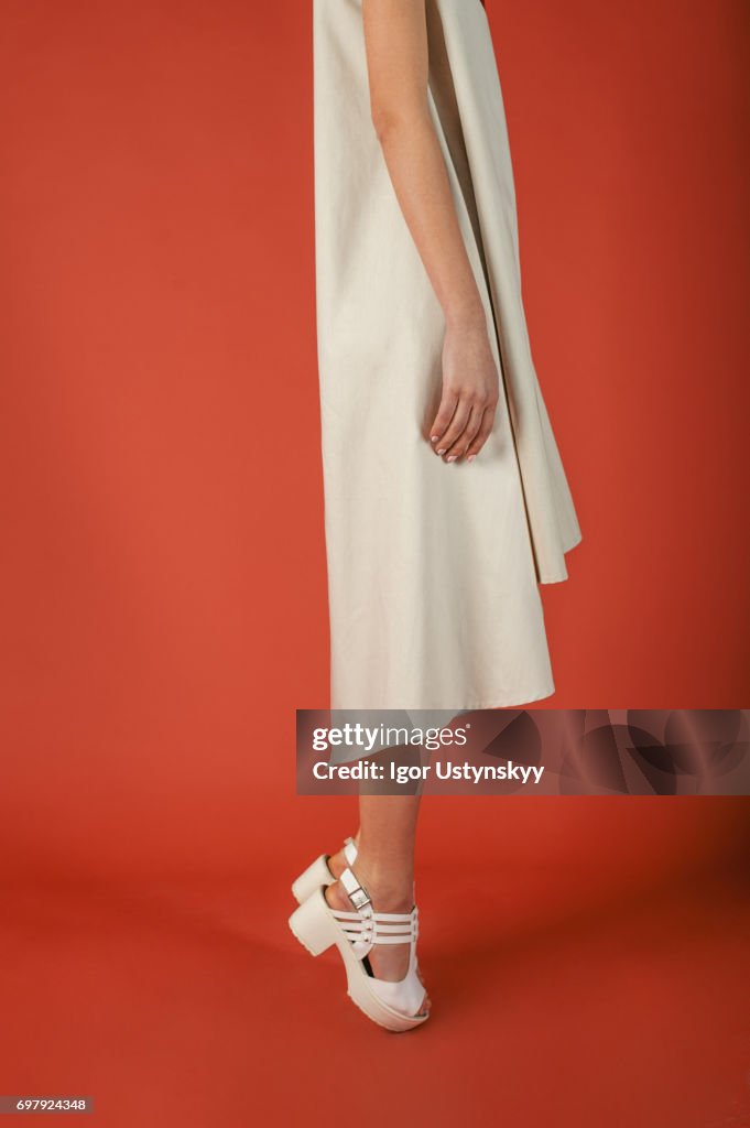 Woman's legs in shoes  in studio on the red background