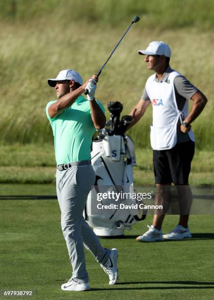 Brooks Koepka of the United States plays his second shot at the par 4, 15th hole watched by his caddie Ricky Elliott during the final round of the...