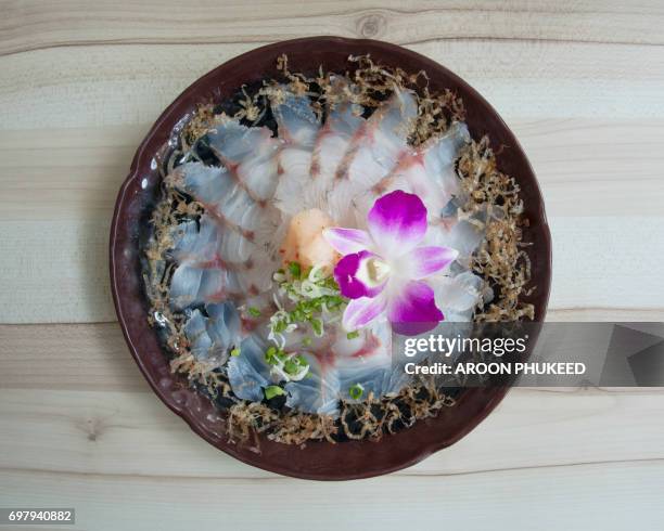 delicious japanese foods of freshly sea bass sashimi sliced and dry fish on the disc. - barramundi stock pictures, royalty-free photos & images