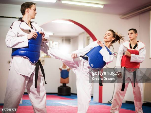 vrouwelijke kampioen taekwondo schoppen op opleiding - taekwando stockfoto's en -beelden