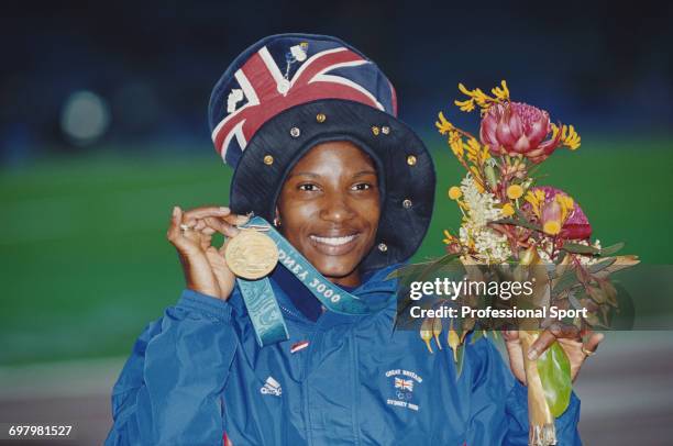 English heptathlete Denise Lewis pictured holding up her gold medal after finishing in first place for Great Britain in the Women's heptathlon event...