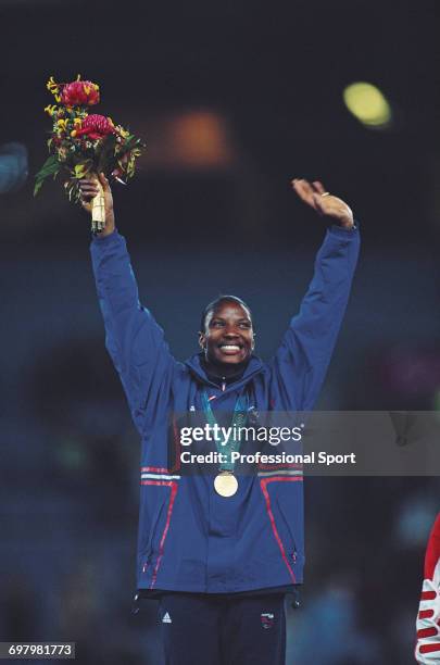 English heptathlete Denise Lewis pictured waving in celebration on the medal podium after finishing in first place to win the gold medal for Great...