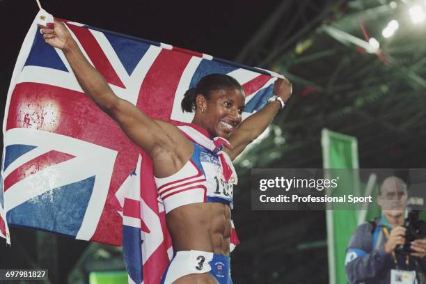 English heptathlete Denise Lewis pictured holding a union jack flag in celebration after finishing in first place to win the gold medal for Great...